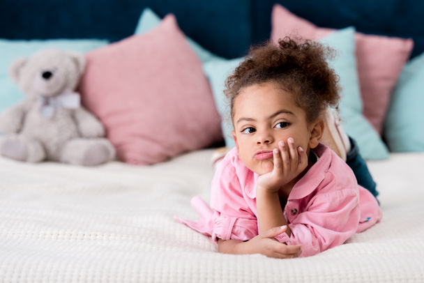 Upset African american kid lying on the bed - Photo, Image