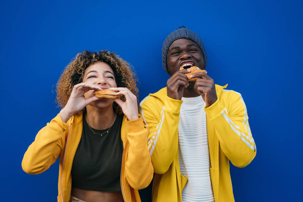 Nuori pari syö hampurilainen ulkona
 - Valokuva, kuva