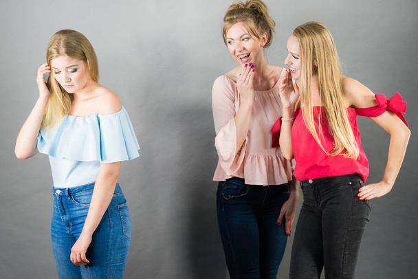 Woman being bullied by two female friends gossiping about her. Friendship rivaly and envy problems. - Valokuva, kuva