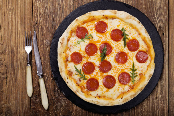 Pizza peperoni on stone black try with rocket and mozzarella cheese - Zdjęcie, obraz
