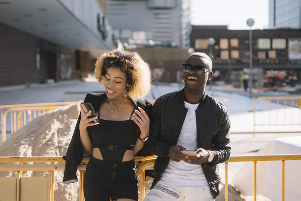 Афро пара с помощью смартфона на улице
 - Фото, изображение