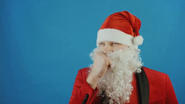 Christmas and New year, wondered man like a Santa thinks and ponders, on blue background - Filmati, video