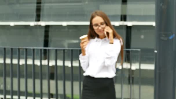 4k. Ελκυστική γυναίκα, σταθείτε κοντά στο γραφείο, μιλάμε από smartphone και χαμόγελα. Προσέγγιση σκηνή - Πλάνα, βίντεο