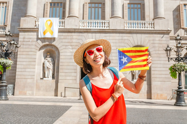 Frau mit katalanischer Flagge vor dem Hintergrund des Rathauses von Katalonien, Barcelona - Foto, Bild