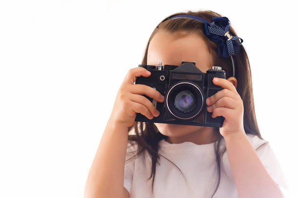 Little girl holding retro camera on white background  - Photo, image