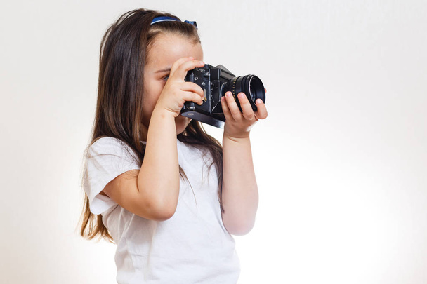 Little girl holding retro camera on white background  - Fotografie, Obrázek