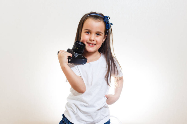 Little girl holding retro camera on white background  - Foto, Imagem