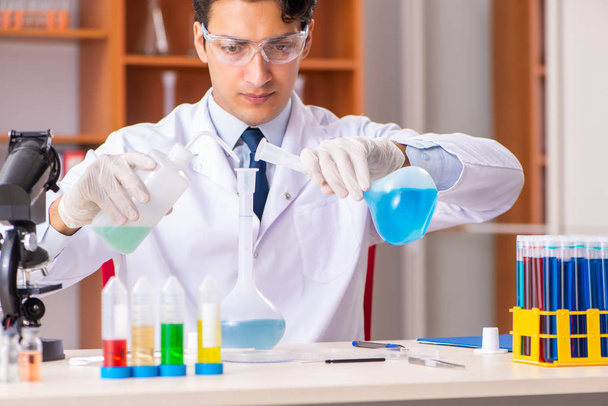 Joven bioquímico guapo trabajando en el laboratorio
  - Foto, Imagen