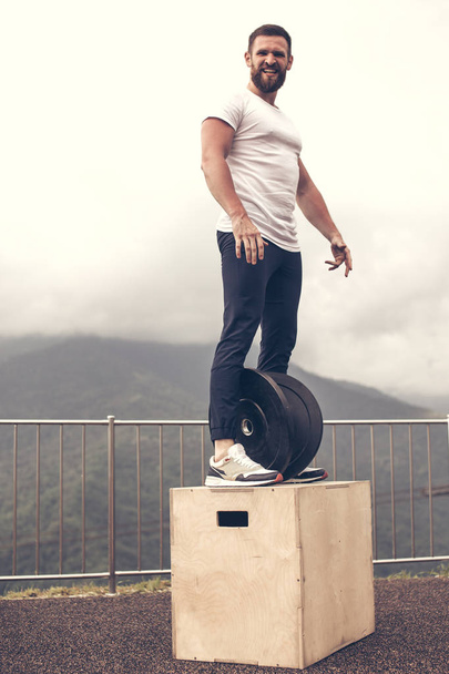Strong male athlete on functional training outdoor on top of mountain. - Foto, imagen