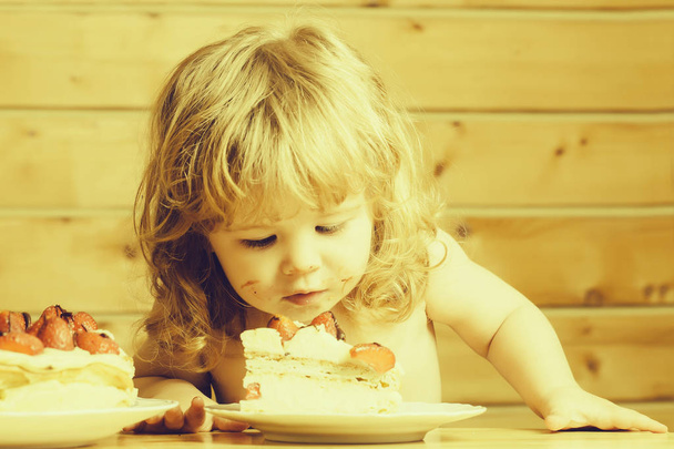 small boy eats strawberry cake - Foto, imagen