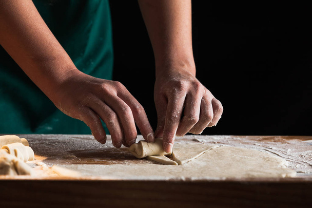 Mãos de uma cozinheira chef amassar massa
 - Foto, Imagem