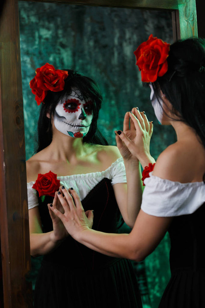 Photo of witch girl with white face and red flower on her head - Foto, immagini
