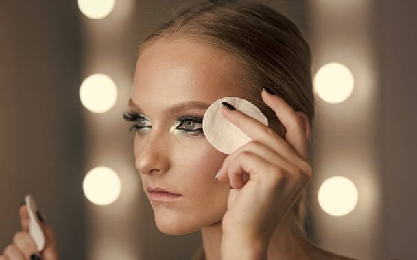 Žena použít vatový tampon na čištění kůže obličeje. Žena odstranit make-up s vatovým tampónkem. Beauty model s novou tvář kůže, péče o pleť. Nalíčení nebo odstranění. Kosmetika, ošetření a terapie - Fotografie, Obrázek