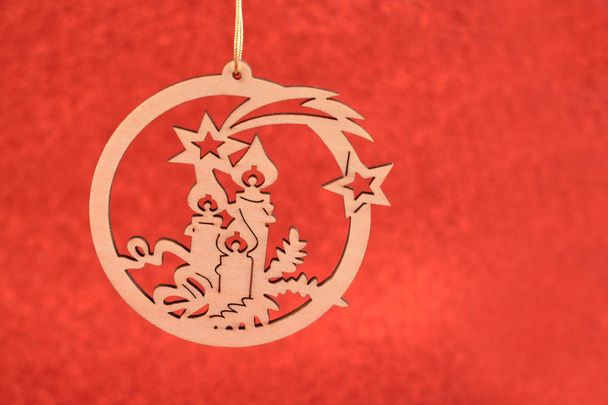 Gesneden kerst decoratie stock afbeeldingen. Gesneden houten ornament. Kerstdecoratie op een rode achtergrond. Vakantie achtergrond met kopie ruimte voor tekst - Foto, afbeelding