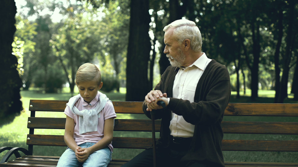 Oude man geeft advies aan droevige, eenzame jongen die lijdt aan pesten op school, zorg - Video