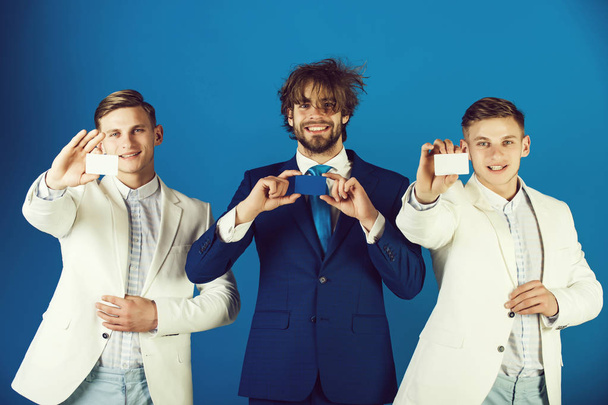 Happy men wearing formal suits. Information and cooperation. Business ethics concept. Businessmen showing blank cards. Group of people posing on blue background. - Fotoğraf, Görsel