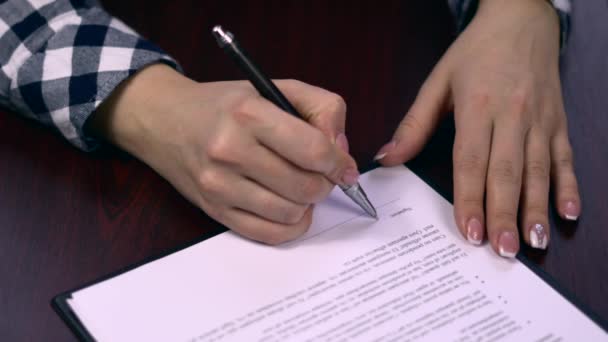 Nahaufnahme einer Geschäftsfrau, die die Seiten eines Papierdokuments oder eines Vertrages unterschreibt. Unterschrift auf einem Blatt Papier des Vertrages. Kugelschreiber bei der Unterschrift auf einem Blatt Papier des Vertrages - Filmmaterial, Video