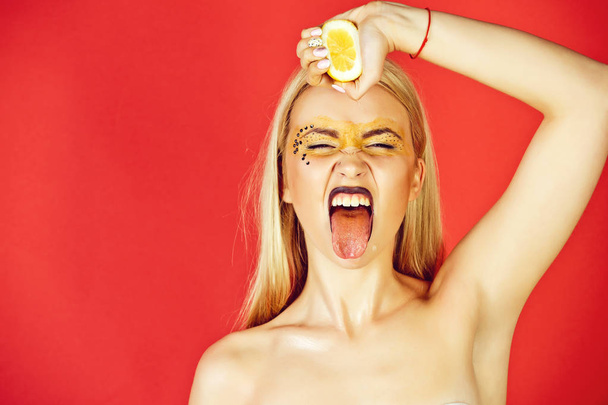 pretty blonde woman with creative fashionable makeup drink lemon, vitamin - Foto, Bild