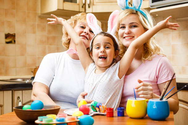 feliz familia pintura huevos de Pascua en casa
 - Foto, imagen