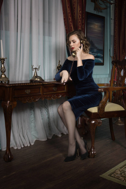 Beautiful attractive woman in the vintage interior speaks by phone - 写真・画像