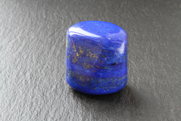 Блакитний лінивий камінь на дошці з чорного каменю
 - Фото, зображення
