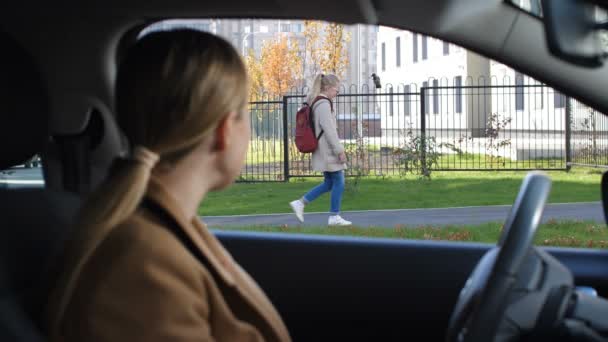 Uczennica, machając na pożegnanie matki przed szkołą - Materiał filmowy, wideo