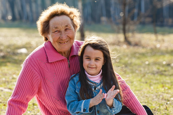 Glückliche Großmutter verbringt Zeit mit Enkelin im Park - Foto, Bild