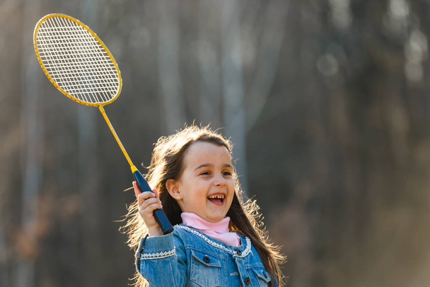 Little girl playing badminton in park - Foto, Imagen