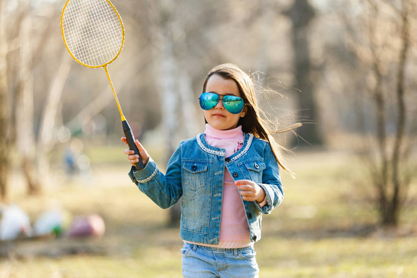 holčička hrát badminton na jarní louce - Fotografie, Obrázek