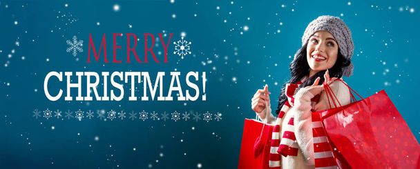 Merry Christmas message with woman holding shopping bags - Photo, image