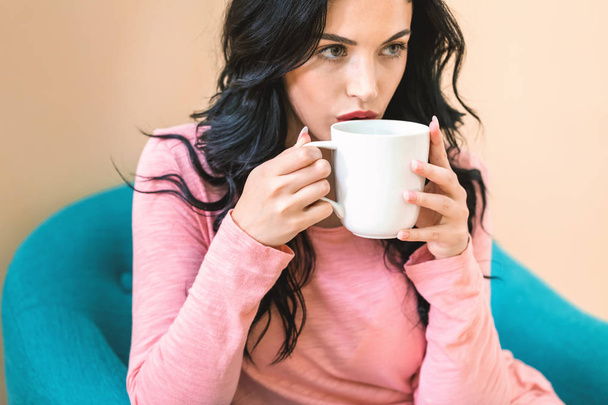 Молодая женщина пьет кофе - Фото, изображение
