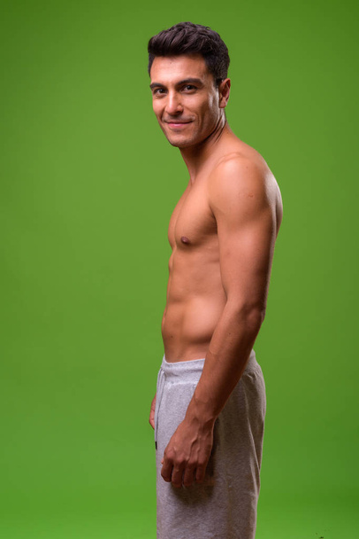 Joven hombre hispano guapo sin camisa sobre fondo verde
 - Foto, imagen