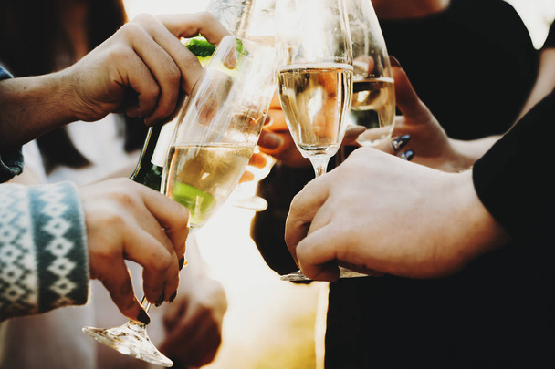 Crop hands of anonymous people clinking glasses of champagne while celebrating on sunny day in countryside - Фото, зображення