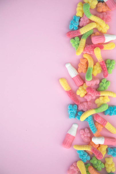 Different gummy candies on a pink background - Foto, afbeelding