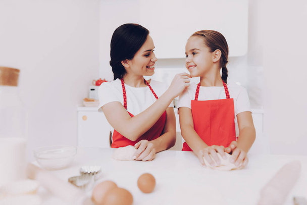 Mom Praises Little Girl for a Good Work in the Kitchen. Cooking For Family. Happy Time. Aproan for Good Girl and Young Mom. Preparation for Young Mom. Girl and Mom Happy Time. Kitchen and Happy Women. - 写真・画像
