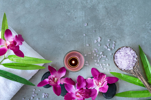 Thai Spa.  Top view of hot stones setting for massage treatment and relax with purple orchid on blackboard with copy space.  Green leaf with black stones pile for spa therapy.  Lifestyle and Healthy Concept. - Foto, Imagem