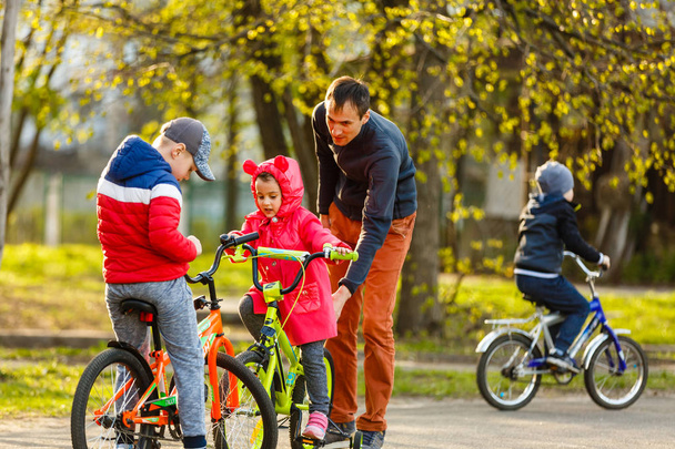 hombre enseñando a los niños a andar en bicicleta - Foto, Imagen