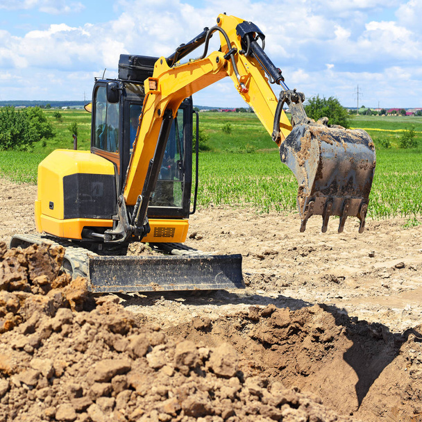 現代の掘削機は、建設現場で発掘作業を実行します。  - 写真・画像