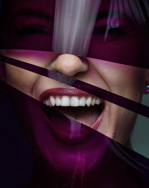 Closeup portrait of a pretty woman posing with a plastic, purple tape - Фото, зображення