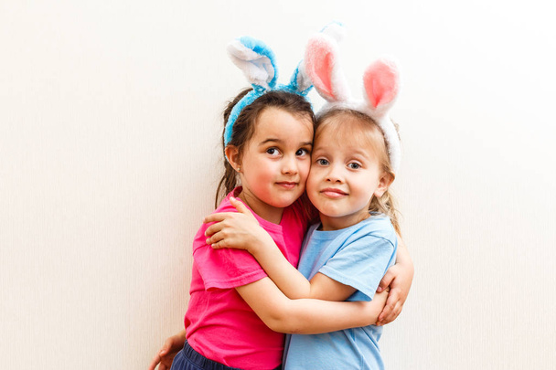 Two little girls with bunny ears isolated on white background - Valokuva, kuva