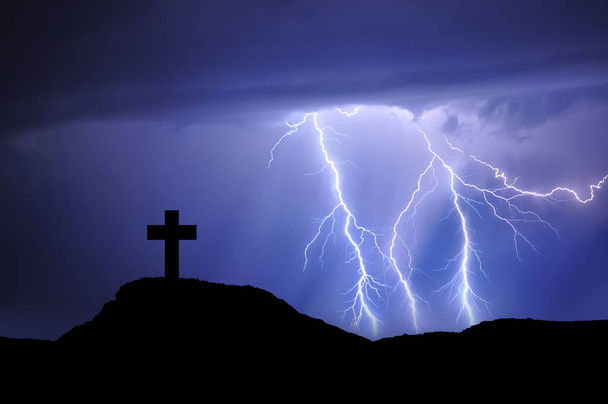 Silhouette eines Kreuzes auf dem Berg mit Strahlen und schlechtem Wetter, Spanien - Foto, Bild