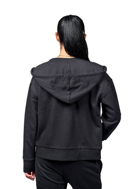 Mädchen-Modell im schwarzen Trainingsanzug Rückansicht auf weißem Hintergrund - Foto, Bild
