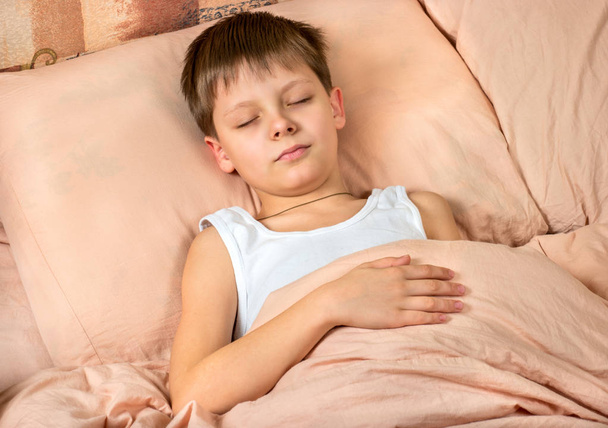 Yatakta yatan genç bir çocuk portresi - Fotoğraf, Görsel