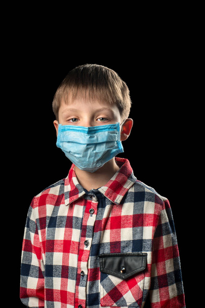 Άρρωστο αγόρι σε μια ιατρική μάσκα σε μαύρο φόντο - Φωτογραφία, εικόνα