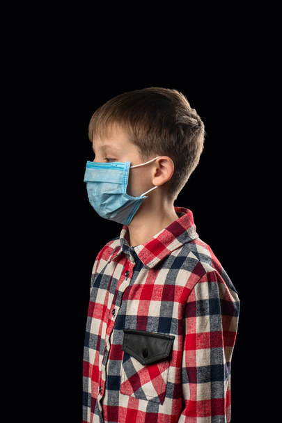 Больной мальчик в медицинской маске на черном фоне
 - Фото, изображение