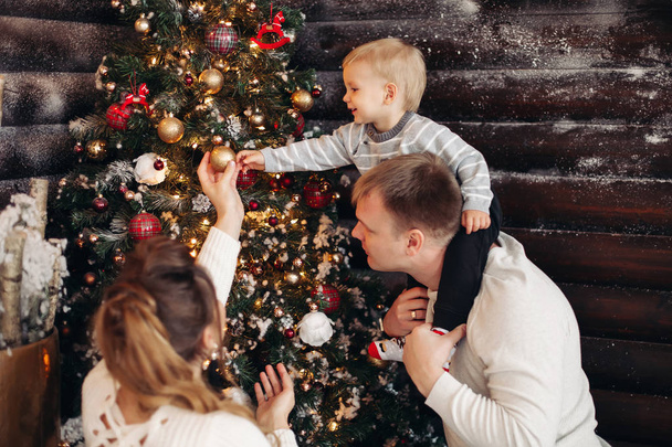Apja és a gyerek díszíti a karácsonyfát. Karácsonyi dekoráció. - Fotó, kép
