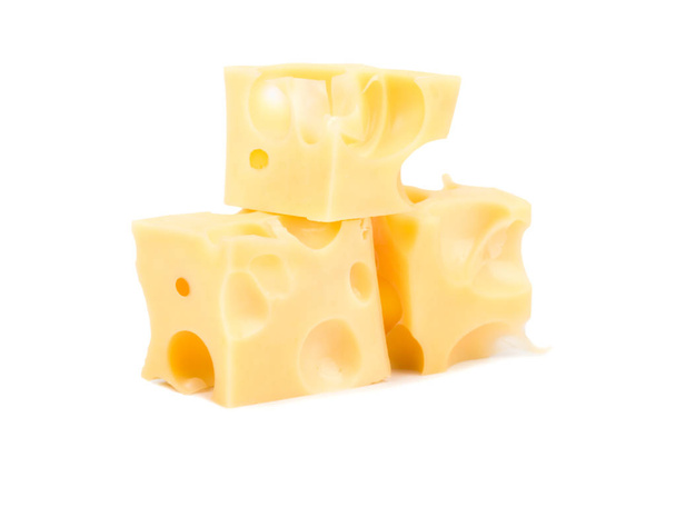Drie blokjes kaas met gaatjes op een witte achtergrond - Foto, afbeelding