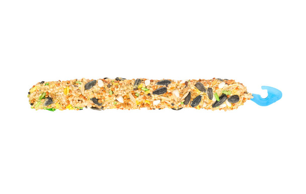 Alimento para loros con varios cereales en un palo sobre un fondo blanco, vista superior
 - Foto, imagen