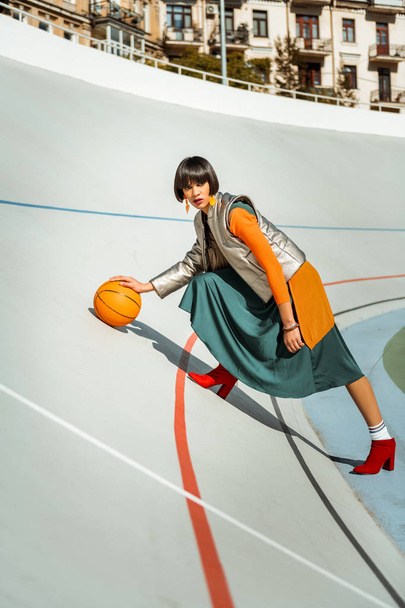Colorful young lady playing basketball wearing glamourous outfit - Fotó, kép