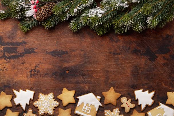 Christmas gingerbread cookies and fir tree branches on wooden backdrop - Φωτογραφία, εικόνα